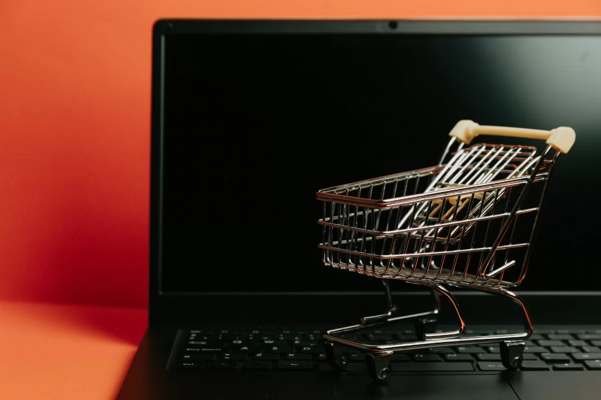 Kis bevásárlókocsi egy laptop billentyűzetén