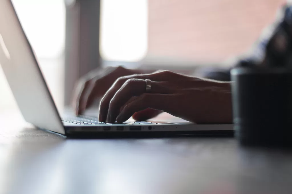 Kéz gépel egy laptop billentyűzetén