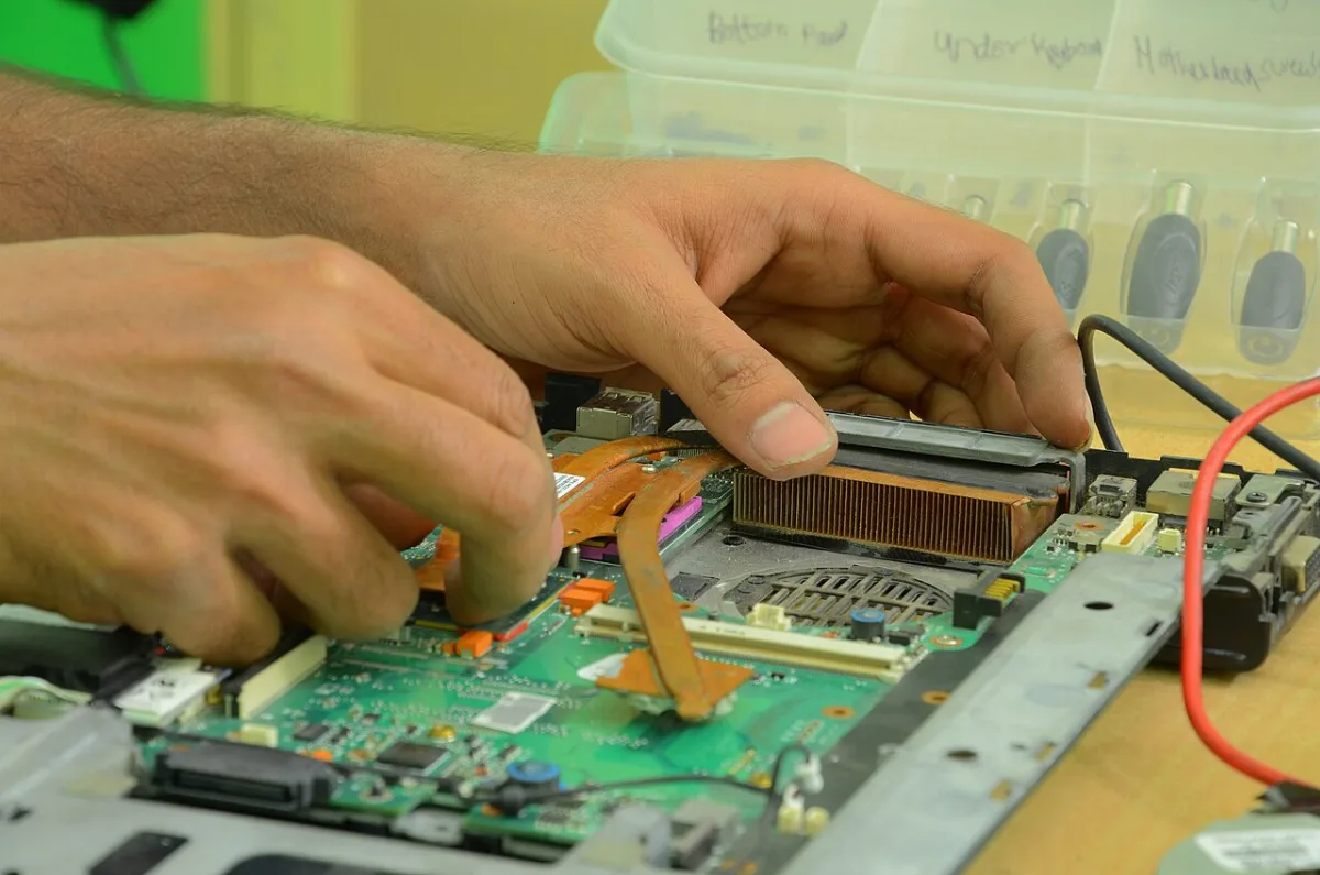 Szétszerelt laptop alaplapja és hűtőbordája javítás közben