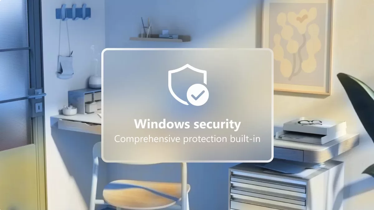 Windows biztonság feliratú kártya pipás pajzs ikonnal egy otthoni dolgozósarok előtt