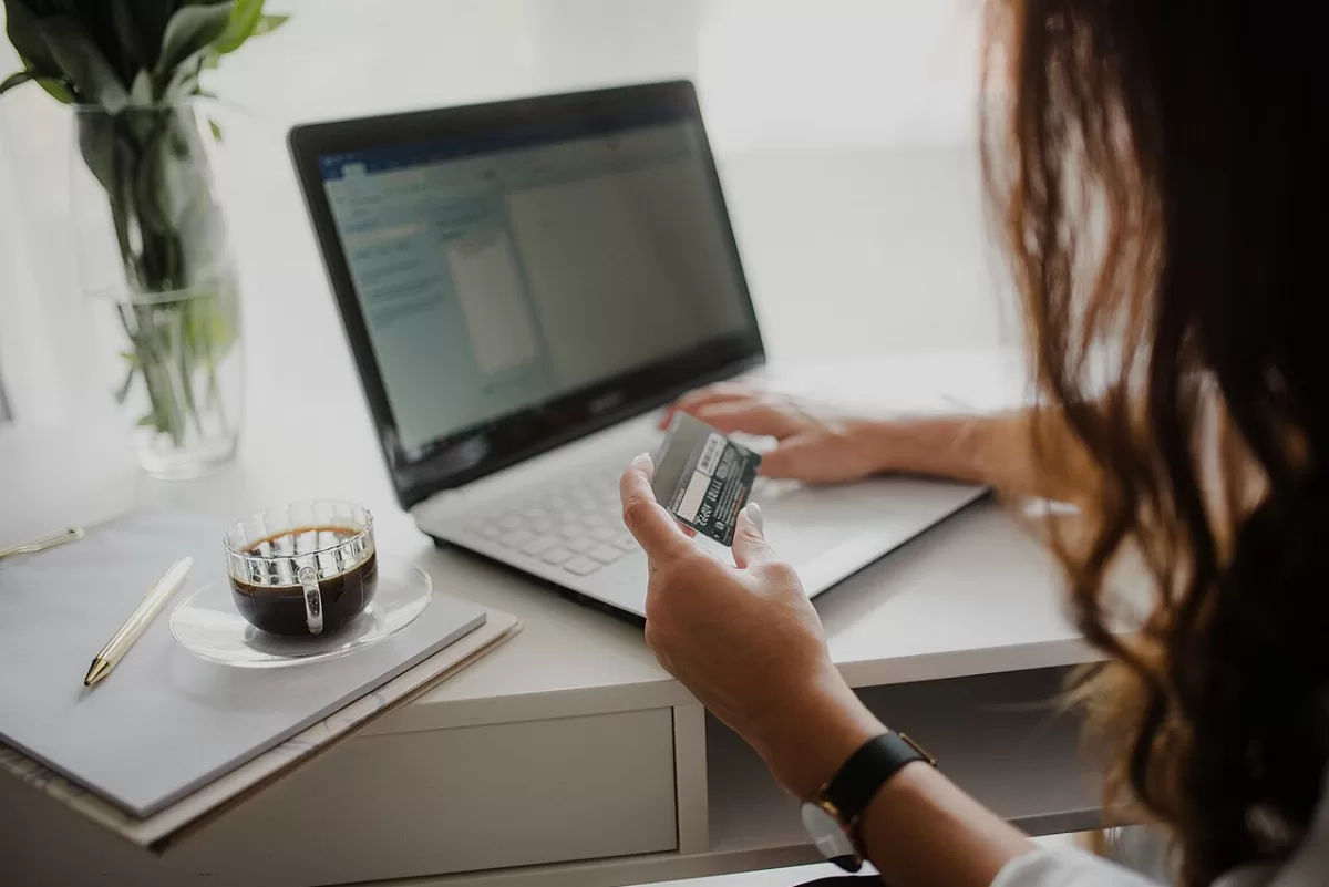 Bankkártya kézben egy laptop előtt